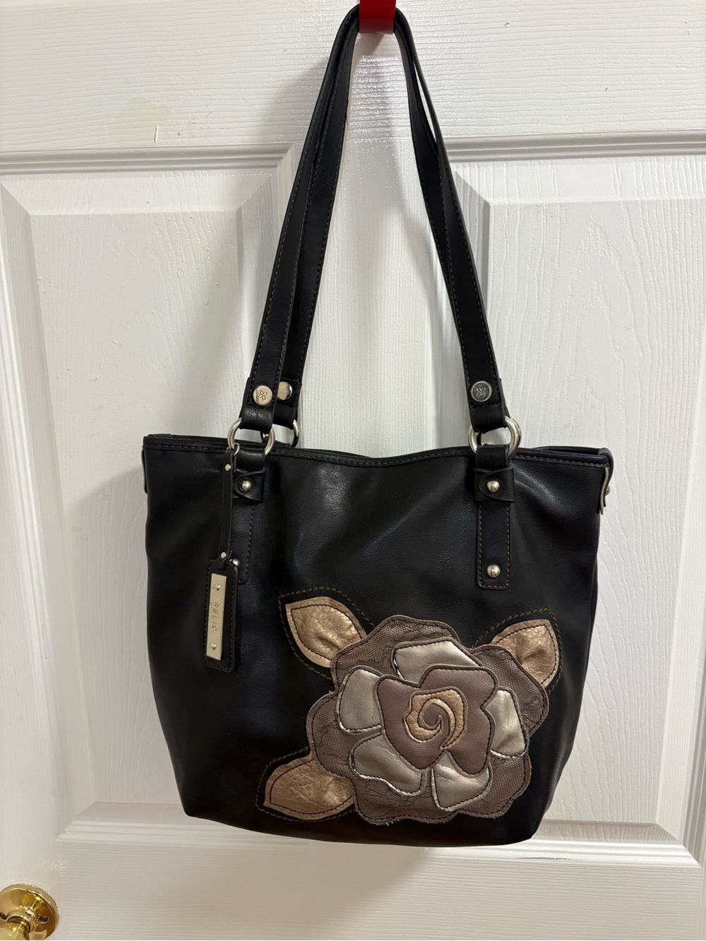 black Relic shoulder bag with a large metallic taupe and bronze rose appliqué .
